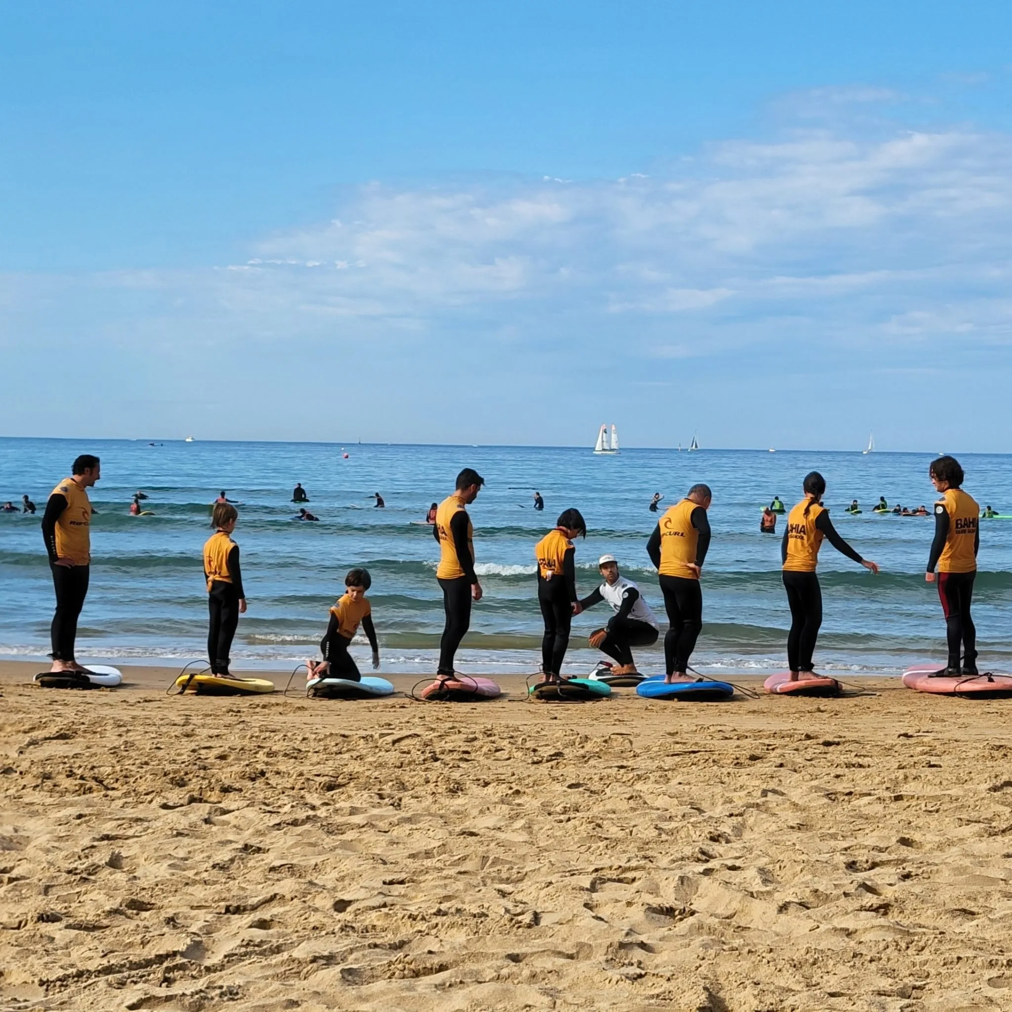 Le groupe debout sur les planches posées sur le sable, face à la mer, pendant l’échauffement.